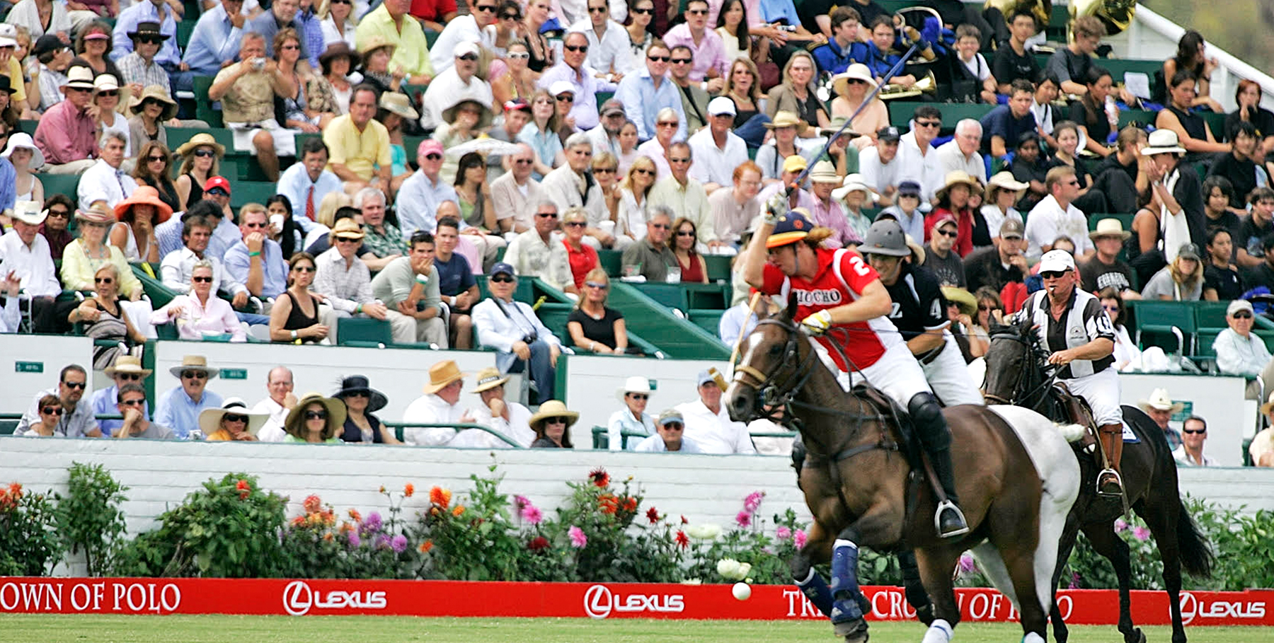 Players in action at a Triple Crown of Polo event with spectators in the background